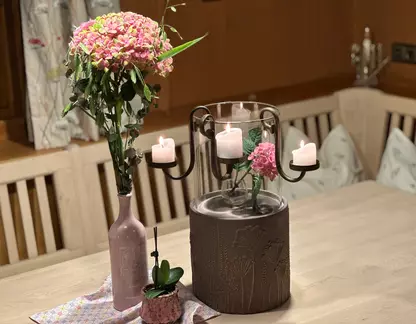 Blumenstrauß und Kerzen auf Holztisch