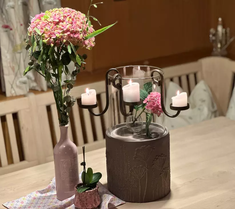 Blumenstrauß und Kerzen auf Holztisch