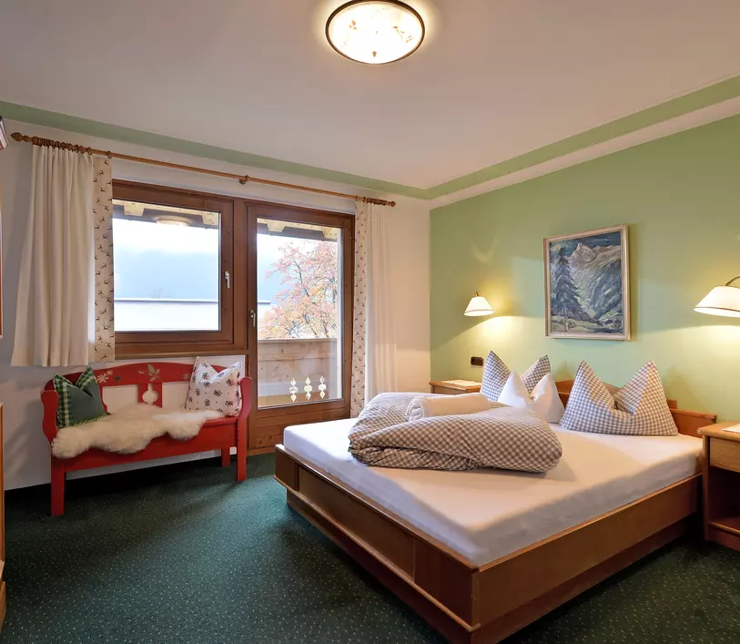 Schlafzimmer mit Doppelbett und Balkon im Appartement Jakob - Landhaus Kumbichl