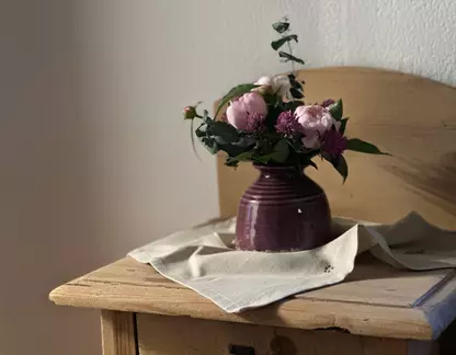 Blumenstrauß in Vase auf Holzkomode
