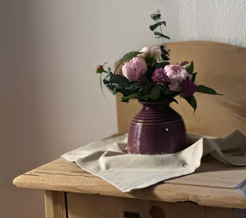 Blumenstrauß in Vase auf Holzkomode
