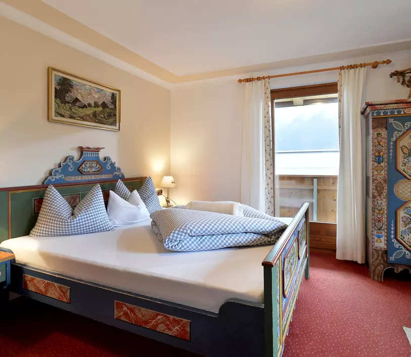 Schlafzimmer mit Doppelbett und Balkon im Appartement Jakob - Landhaus Kumbichl