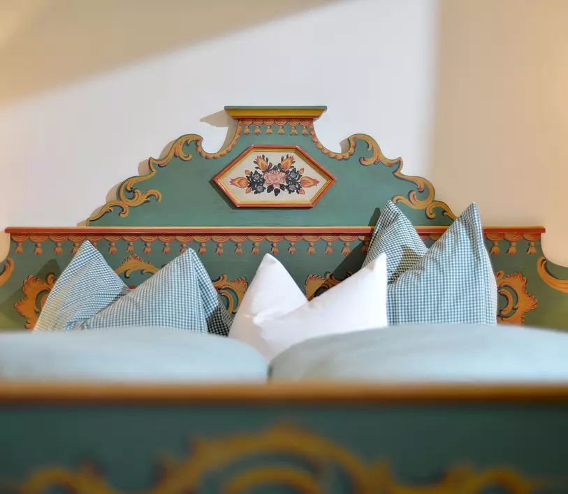 Doppelbett mit verzierten Kopfteil im Appartement Thomas - Landhaus Kumbichl