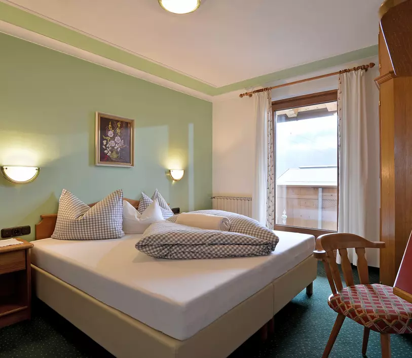 Schlafzimmer mit Doppelbett und Balkon im Appartement Thomas - Landhaus Kumbichl