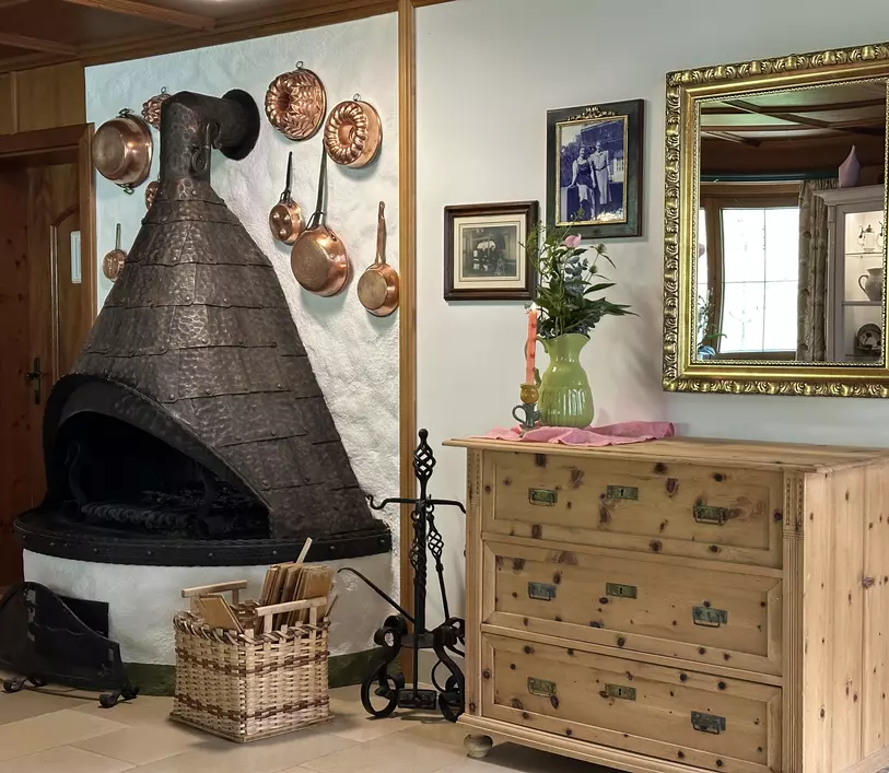 Offener Kamin mit Metallverschlag, Holzkommode und Wandspiegel